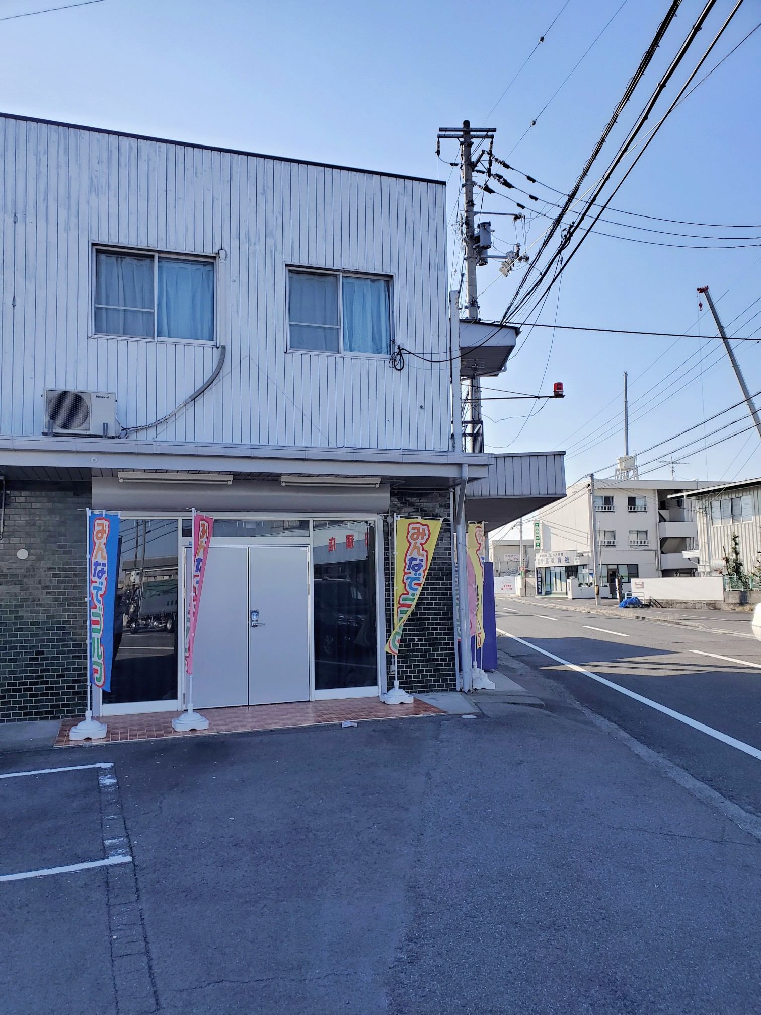 みんなでゴルフの外観。1階の店舗入口にのぼりが立っている